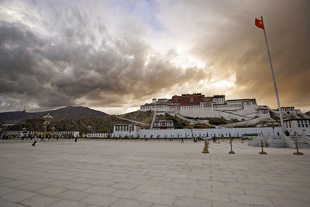 The red flag of China flying in Potala Square on a stormy afternoon in front of the Potala Palace, UNESCO World Heritage Site, Lhasa, Tibet, China, Asia