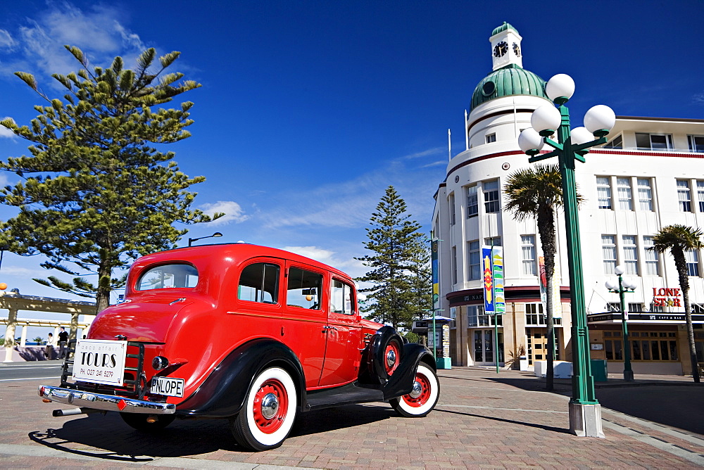 Old red car advertising tours in the Art Deco city, opposite the Deco clock tower, Napier, North Island, New Zealand, Pacific