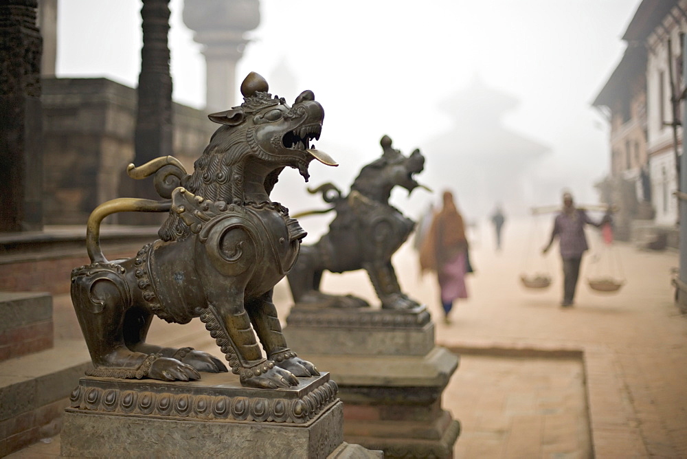 Durbar Square, Bhaktapur, Kathmandu valley, Nepal. Guardian lions on the steps of a temple. Foggy winter morning November 2005.