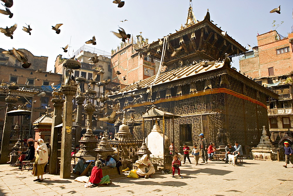 Seto Machendranath temple, close to Durbar Square, Kathmandu, Nepal. Pagoda style gilt roofed temple in a monastic courtyard now housing shops and market stalls.