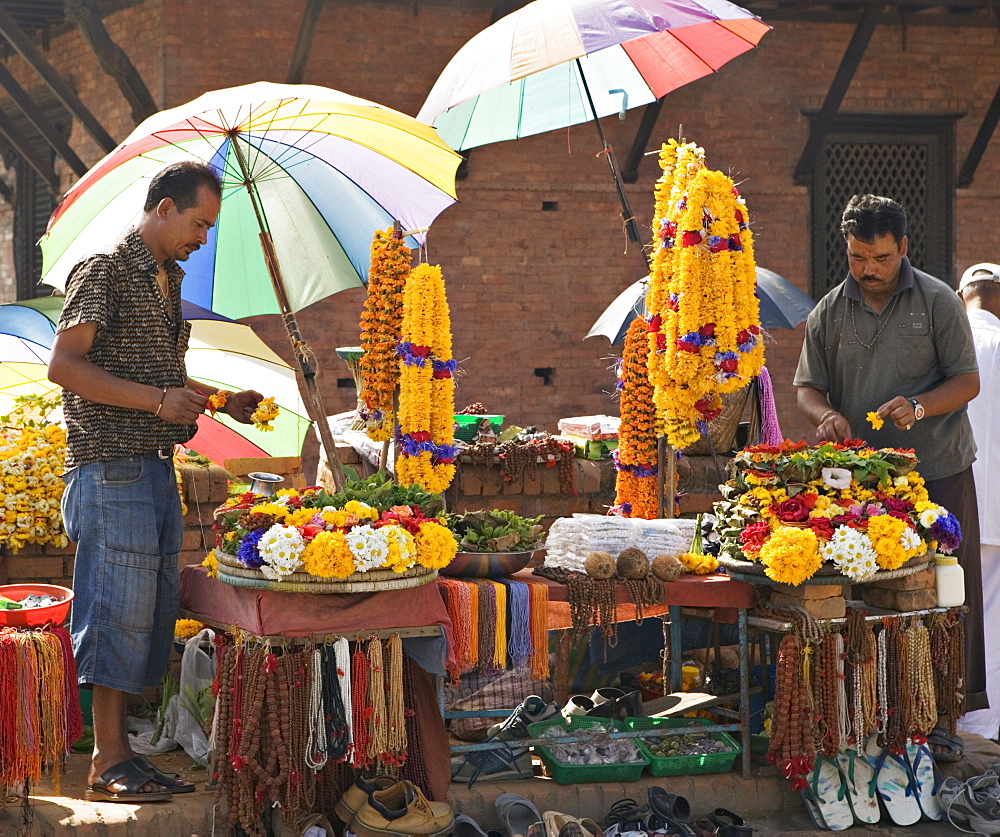 Selling flowers, coconuts and other offerings for the morning pooja ceremony carried out by most Hindus in the valley, Pashupatinath, Kathmandu, Nepal, Asia