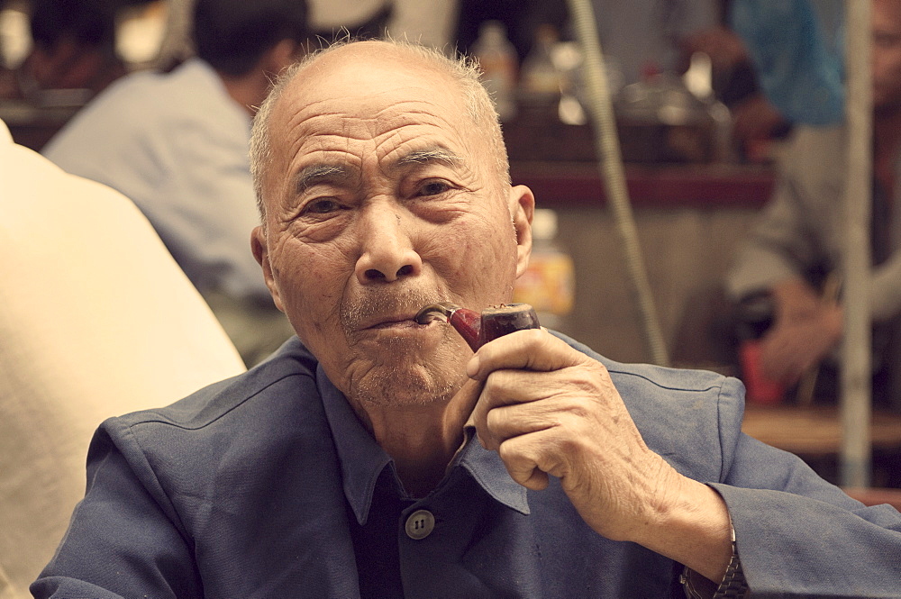 Portrait of a Chinese man smoking pipe, Yangshuo, Guangxi Province, China, Asia