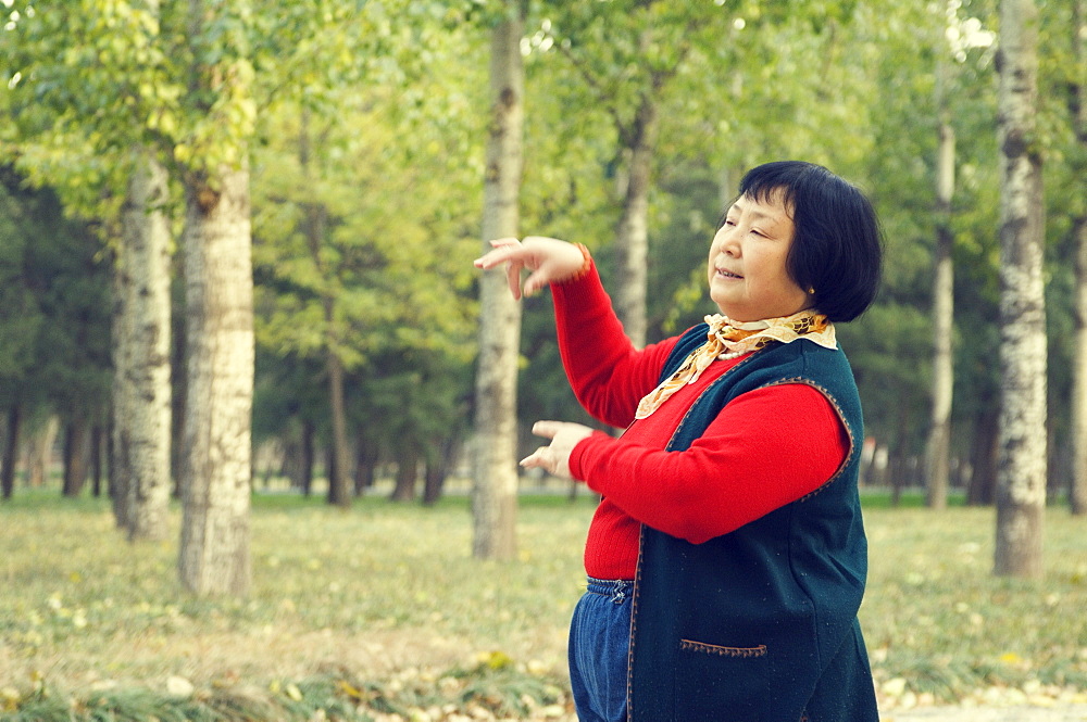 Portrait of a Chinese woman dancing in park, Old Beijing, Beijing, China, Asia