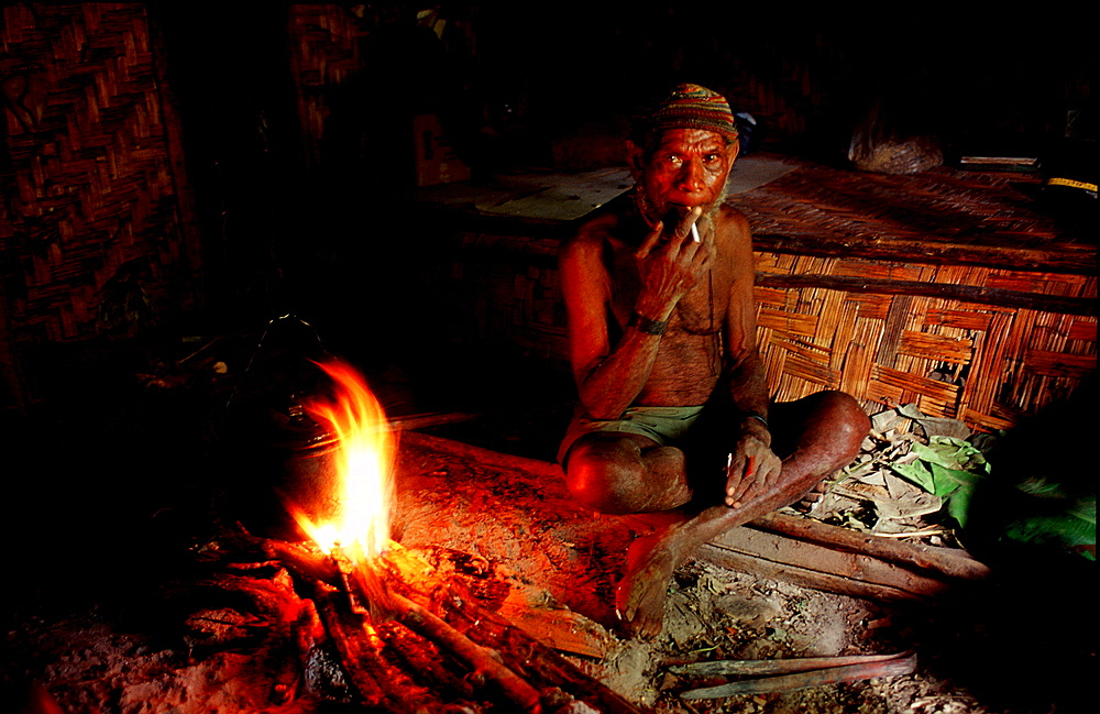 Huli makes fire in his house, Papua New Guinea, Tari, Huli, Highlands