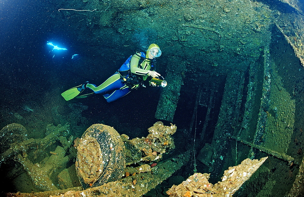 Scuba diver and truck wreck in Blue Belt shipwreck, Sudan, Red Sea, Africa