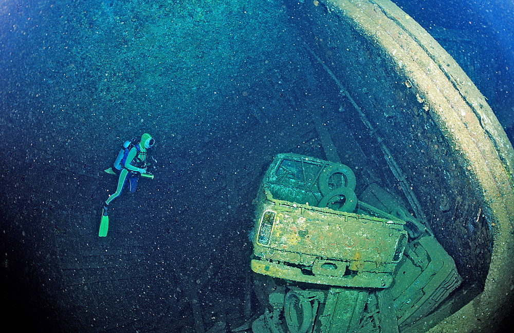 Scuba diver and truck wreck in Blue Belt shipwreck, Sudan, Red Sea, Africa