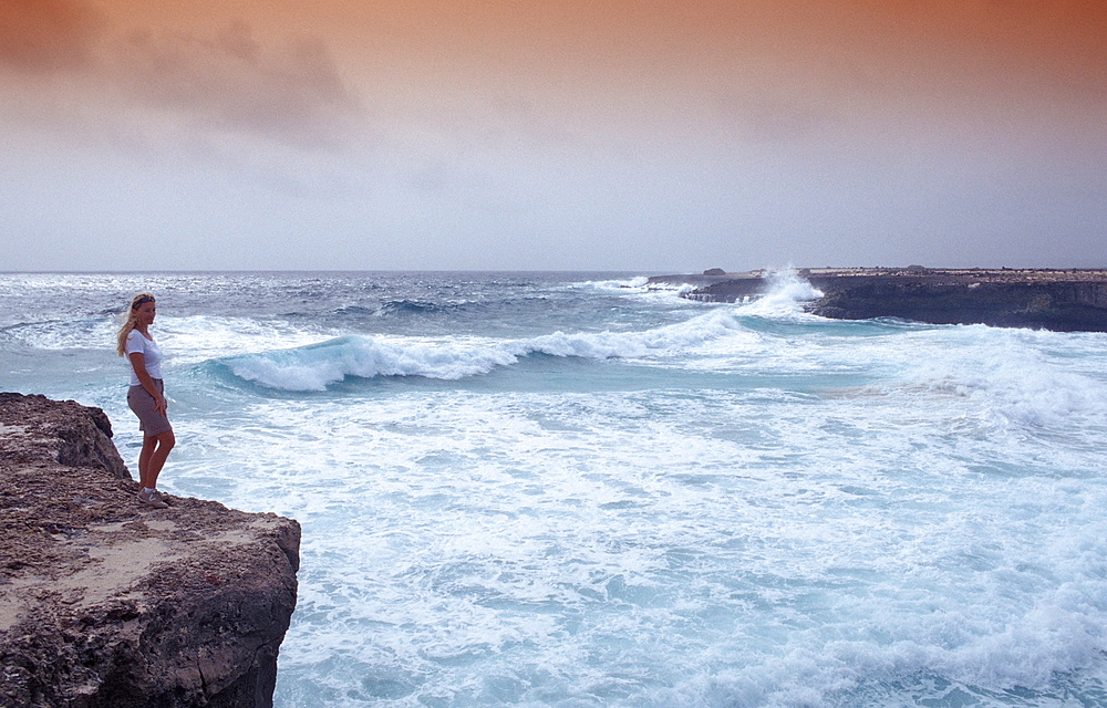 Woman and stormy coast, Netherlands Antilles, Bonaire, Caribbean Sea, Washington Slagbaai National Park, Playa Chikitu