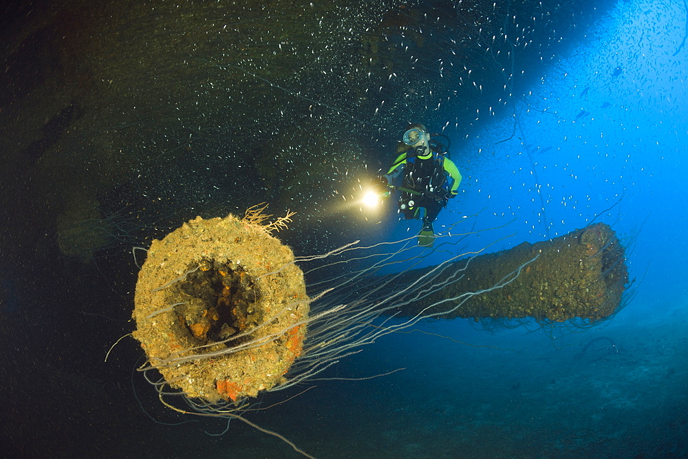 Diver at massive 16-inch 45 Caliber Gun under the HIJMS Nagato Battleship, Marshall Islands, Bikini Atoll, Micronesia, Pacific Ocean