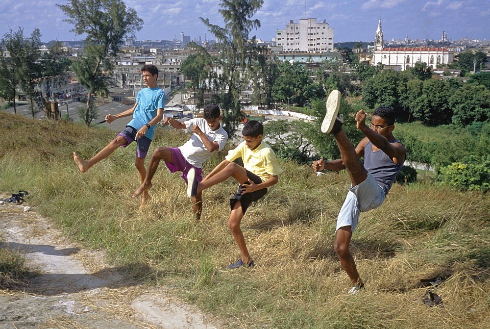 Four boys practicing kick boxing, martial arts moves in the El Cerro area of Havana, Cuba