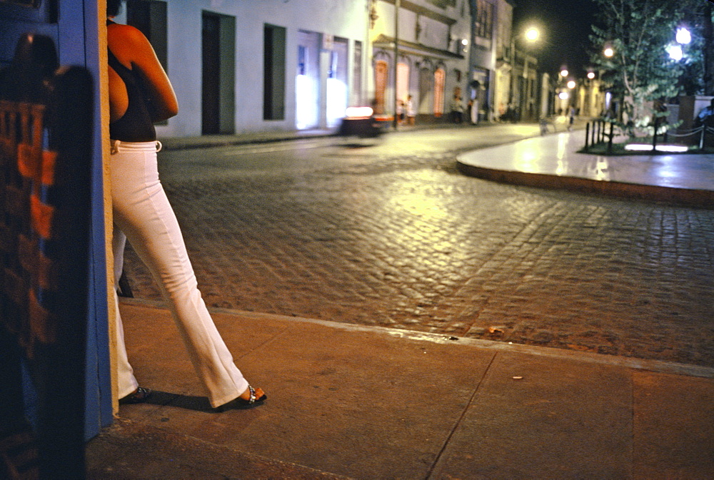 A prostitute standing on a street corner at night in Camaguey in central Cuba, Cuba