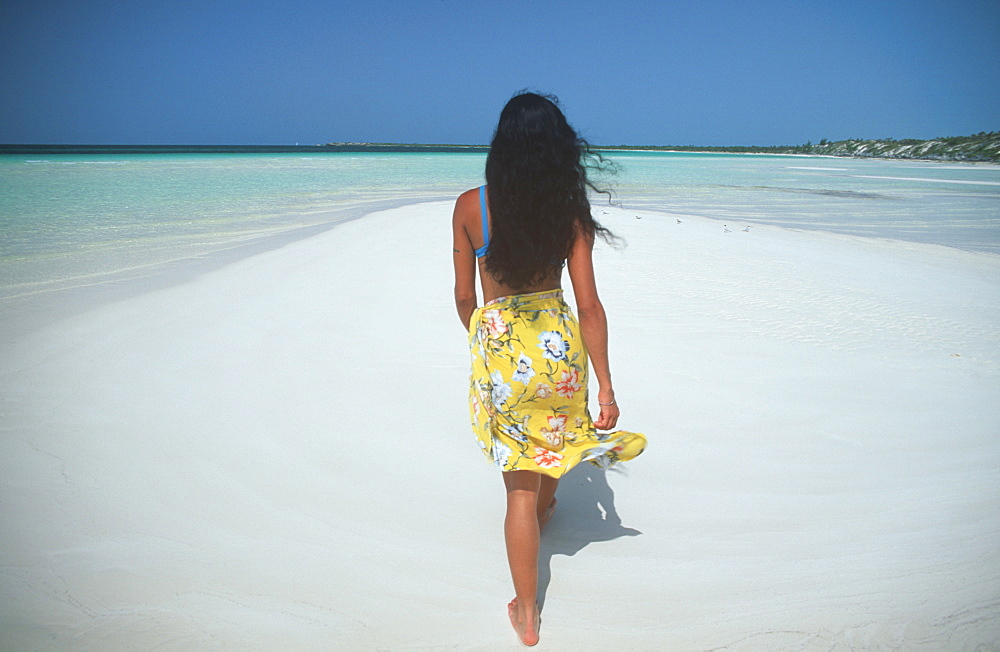 Caya Guillermo near Cayo Coco woman walking toward the sea on Playa Pilar beach, Cuba