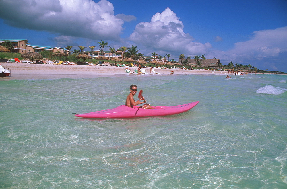 Camaguey Province Santa Lucia Playa los Cocos woman kayaking in sea near beach resorts, Cuba