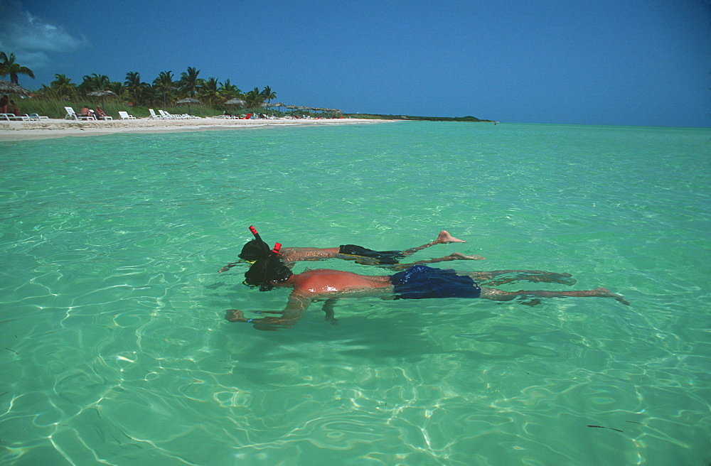 Caya Guillermo near Cayo Coco father and son snorkling off beach resorts, Cuba