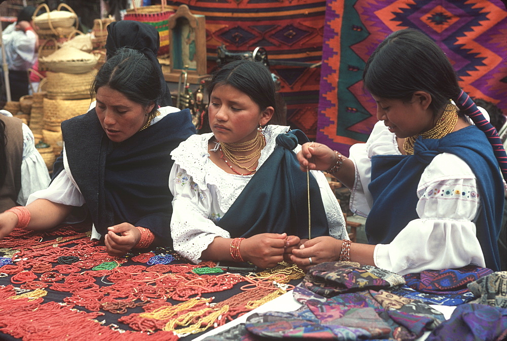 Otavalo, north of Quito is one of Latin Am's most famous markets for textiles, crafts and produce Otavalo women buying necklaces, Quito, Ecuador