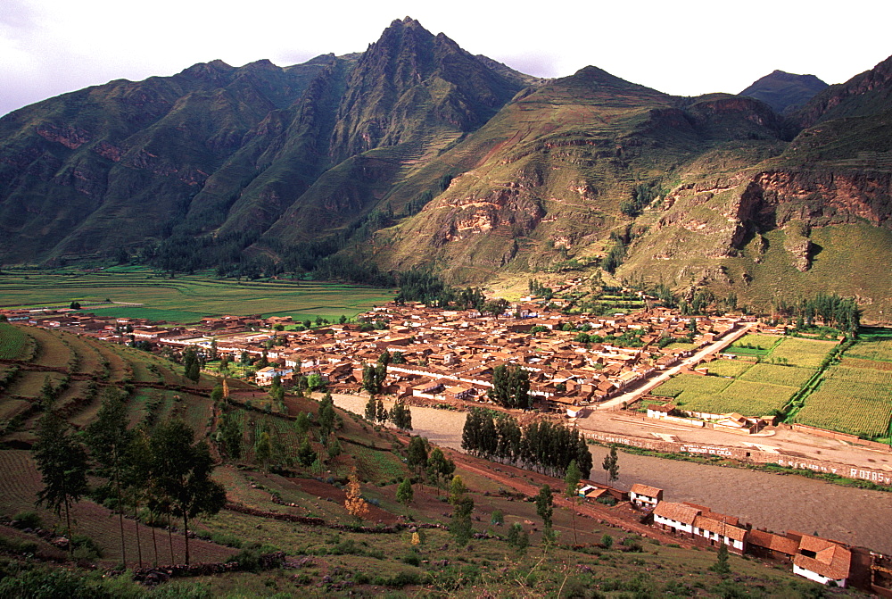 Pisac, beautiful Colonial village on Urubamba River in Incan Sacred Valley with Incan terraced fields on hillside, Cuzco area, Highlands, Peru