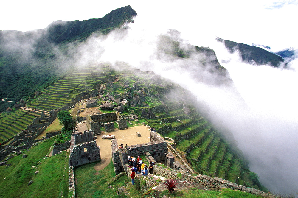 Machu Picchu view from the Intihuatana to the temples around the Sacred Plaza with terraced fields beyond, Highlands, Peru