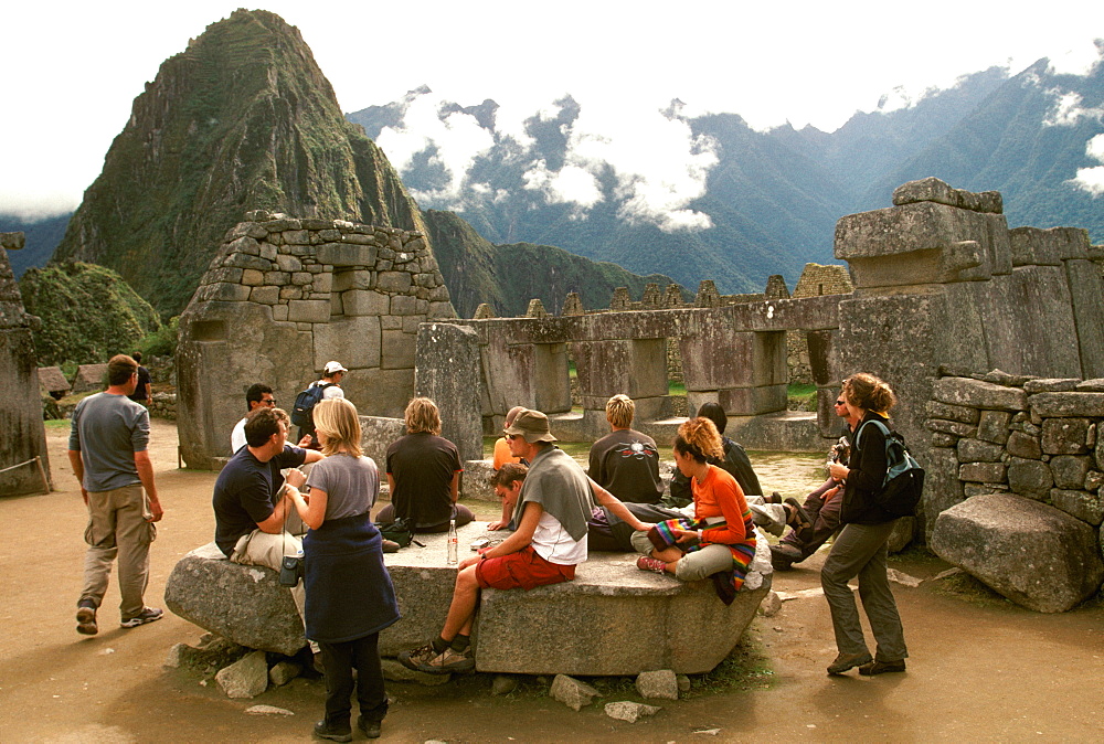 Machu Picchu the ancient city with visitors viewing the temples in the Sacred Precinct, Highlands, Peru