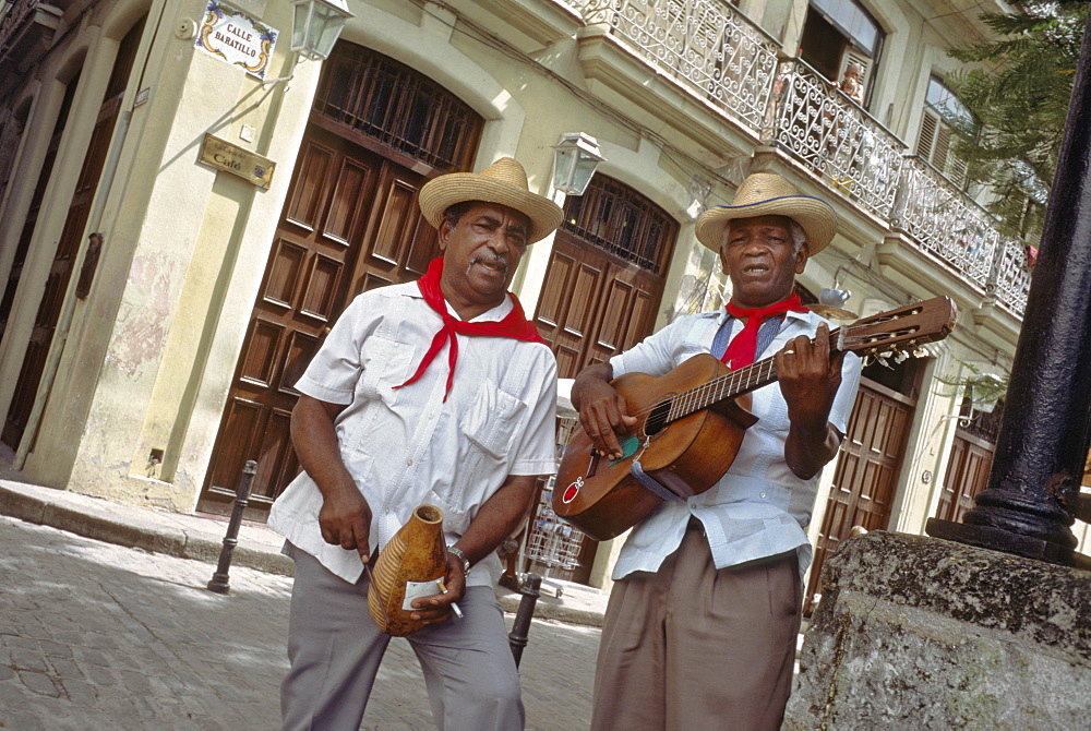 Street musicians entertaining passersby near the Plaza de Armas in Habana Vieja, Havana, Cuba