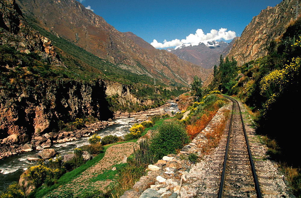 The train from Cuzco to Machu Picchu travels along the Urubamba River Valley with snow capped mountains above, Highlands, Peru