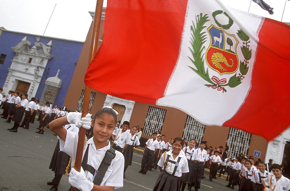 A colonial city on Peru's north coast the Tribute to the Flag Parade on Plaza de Armas portrait of school girl holding a flag, Trujillo, Peru