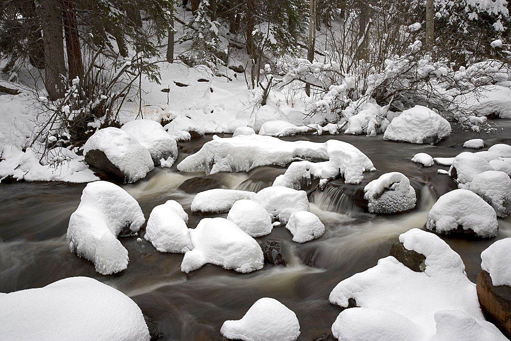 Snow-covered boulders and flowing creek, Glacier Creek, Rocky Mountain National Park, Colorado, United States of America, North America