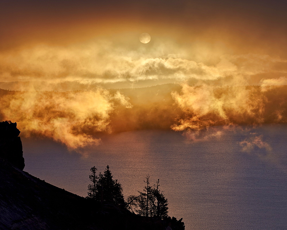 Low clouds glowing orange at sunrise, Crater Lake National Park, Oregon, United States of America, North America 