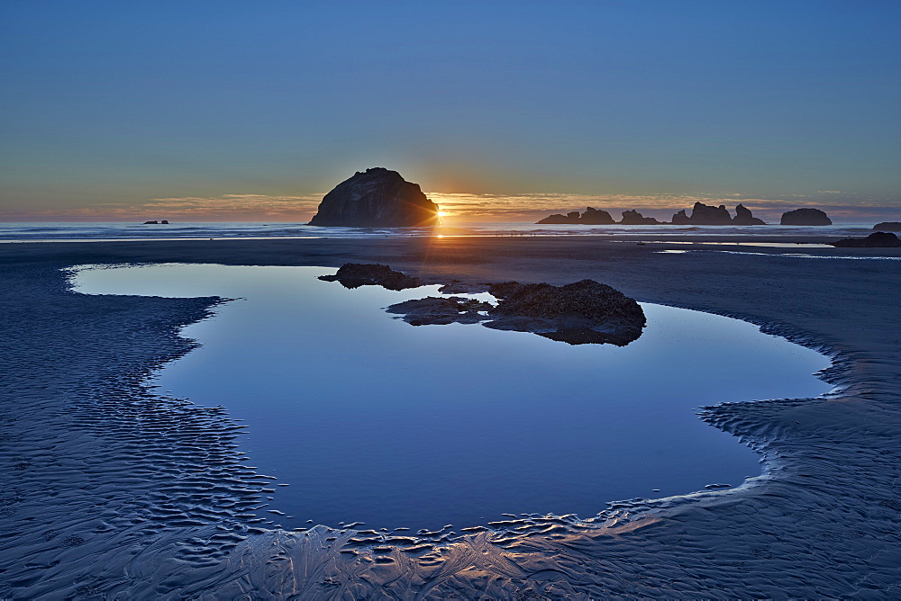 Sunset by a sea stack over a pool on the beach, Bandon Beach, Oregon, United States of America, North America 