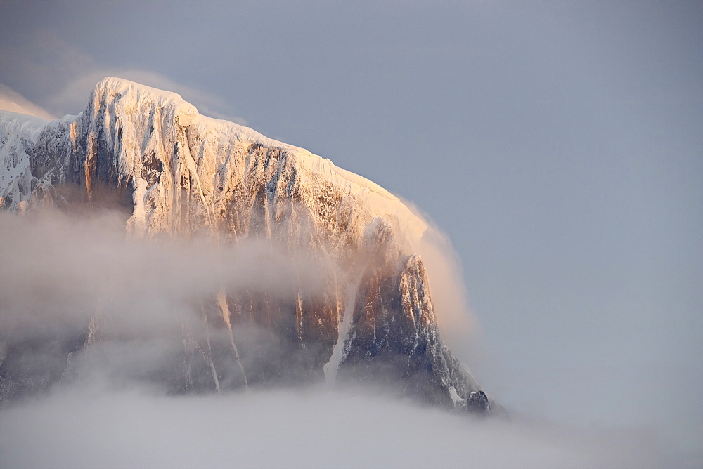 Snow covered mountain at sunset, generating its own fog cover, Wiencke Island, Antarctic Peninsula, Antarctica, Polar Regions