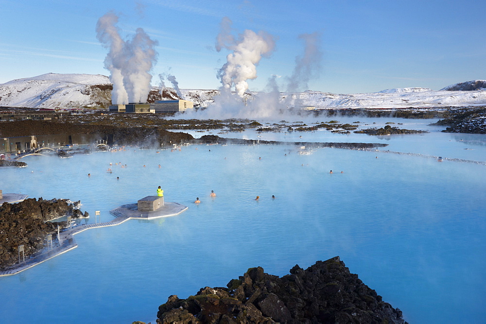 People relaxing in Blue Lagoon geothermal spa, Svartsengi Geothermal Power Station in the distance, Grindavik, Reykjanes Peninsula, Iceland, Polar Regions