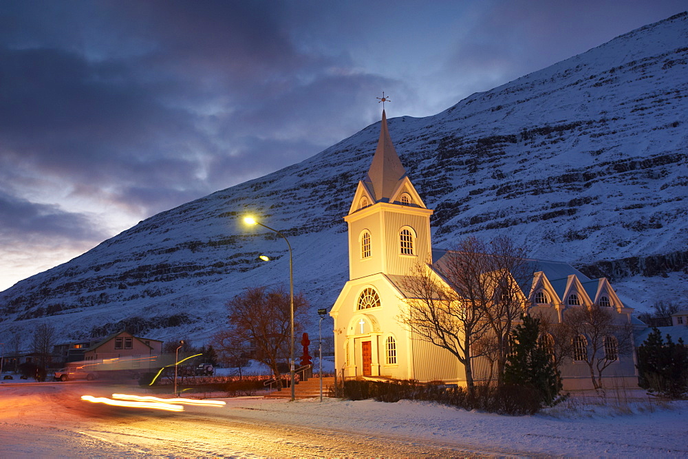 Traditional wooden church at night, built in 1922, at Seydisfjordur, a town founded in 1895 by a Norwegian fishing company, now main ferry port to and from Europe in the East Fjords, Iceland, Polar Regions