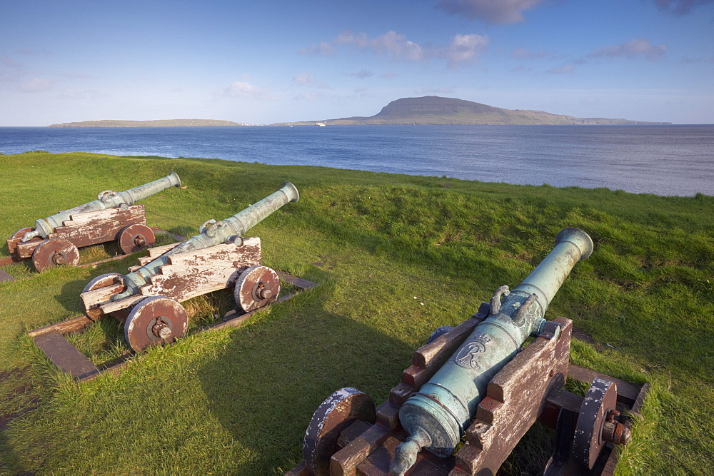 Skansin fort, old fort guarding Torshavn and its harbour, with old brass cannons, Second World War British marine guns and lighthouse, Nolsoy in the distance, Torshavn, Streymoy, Faroe Islands (Faroes), Denmark, Europe