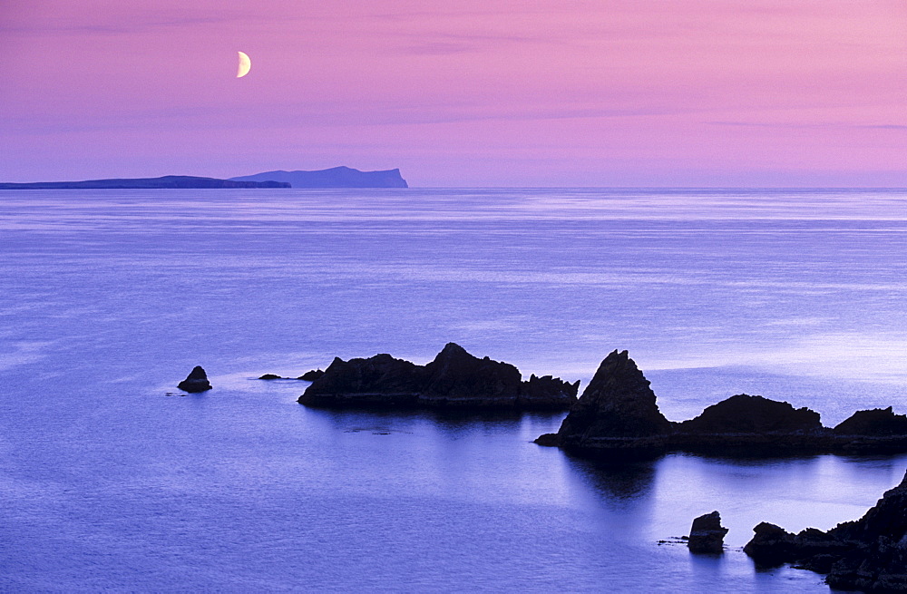 Sunset over Sand Wick and rising moon over Foula in distance, Eshaness, Shetland, Scotland, United Kingdom, Europe