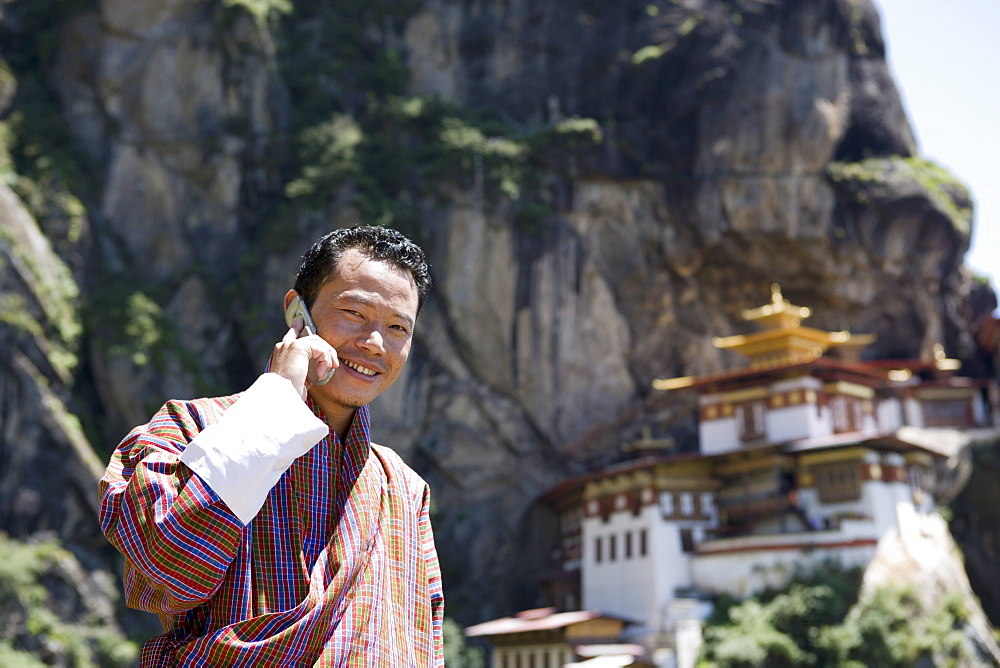 Bhutanese man with cell phone, Taktshang Goemba (Tiger's Nest) Monastery, Paro, Bhutan, Asia