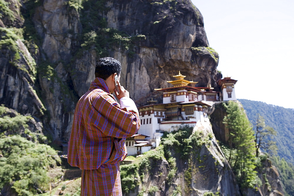 Bhutanese man with cell phone, Taktshang Goemba (Tiger's Nest) Monastery, Paro, Bhutan, Asia