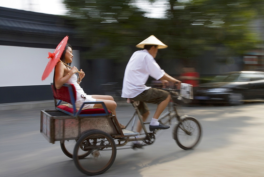 Asian woman (Chinese-Thai) riding in cycle rickshaw, Hutong District, Beijing, China, Asia