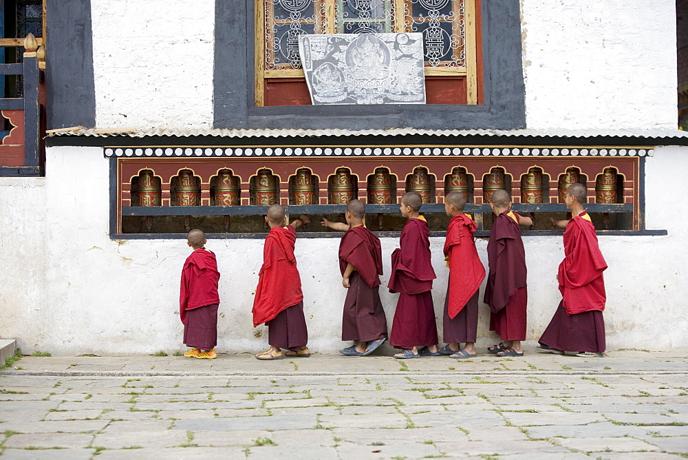 Buddhist monks turning prayer wheels, Karchu Dratsang Monastery, Jankar, Bumthang, Bhutan, Asia