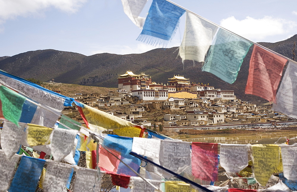 Prayer flags and Ganden Sumsteling Gompa (Gandan Sumtseling) (Songzanlin Si) Buddhist Monastery, Shangri-La, formerly Zhongdian, Shangri-La region, Yunnan Province, China, Asia