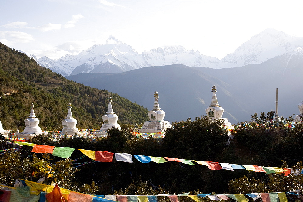 Buddhist stupas with Meili Snow Mountain peak in background, en route to the Tibetan border, Deqin, Shangri-La region, Yunnan Province, China, Asia