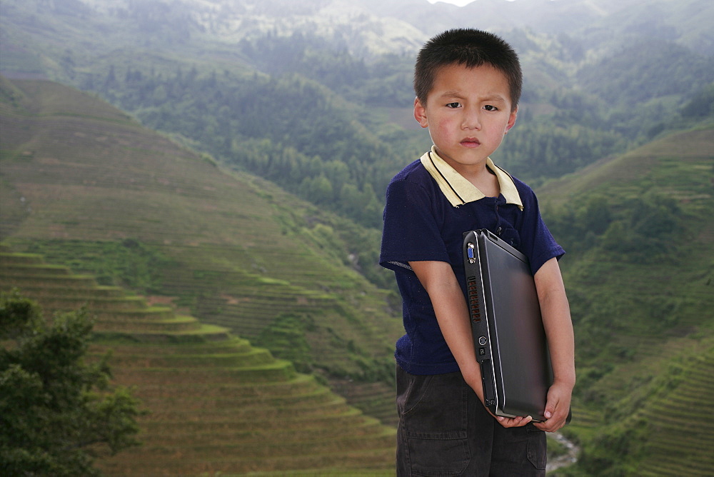 Boy of Yao mountain tribe minority with laptop, Longsheng terraced ricefields, Guangxi Province, China, Asia