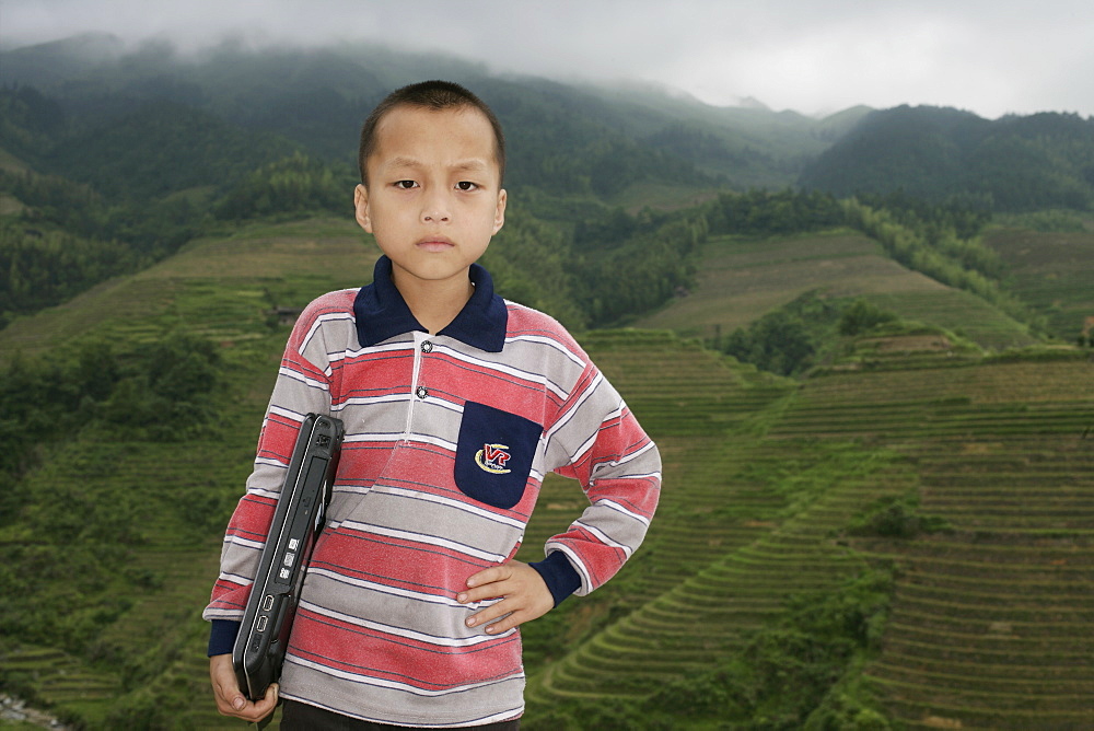 Boy of Yao mountain tribe minority with laptop, Longsheng terraced ricefields, Guangxi Province, China, Asia