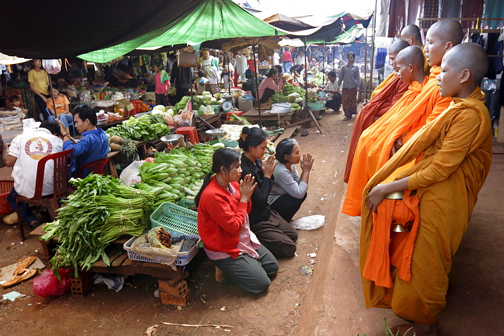 Buddhist monks collecting alms in the market town of Phum Swai Chreas, eastern Cambodia, Indochina, Southeast Asia, Asia