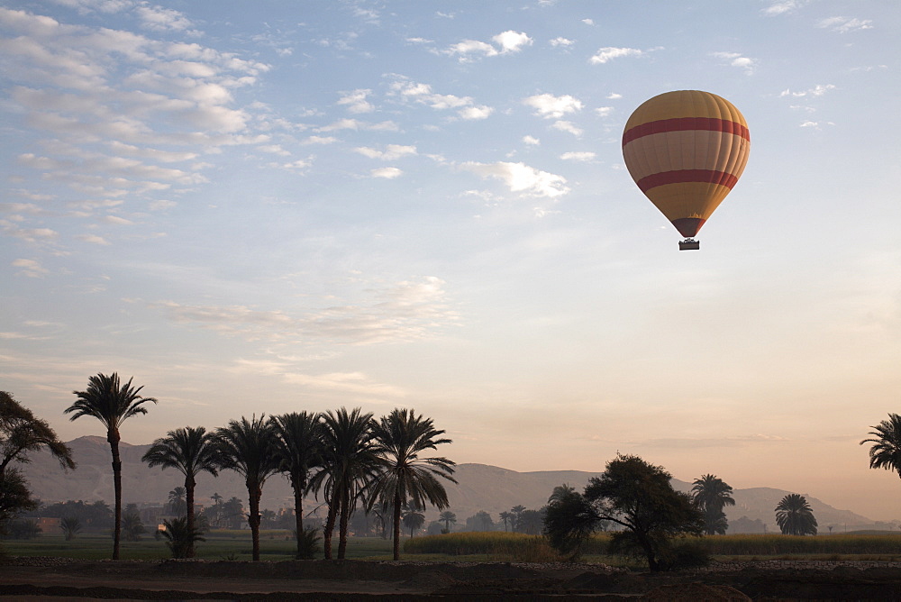 Hot air balloons carry tourists on early morning flights over the Valley of the Kings, Luxor, Egypt, North Africa, Africa