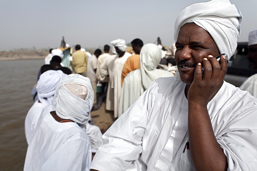 A Sudanese man talks on his mobile phone during a Nile ferry crossing to the town of Dongola, Sudan, Africa