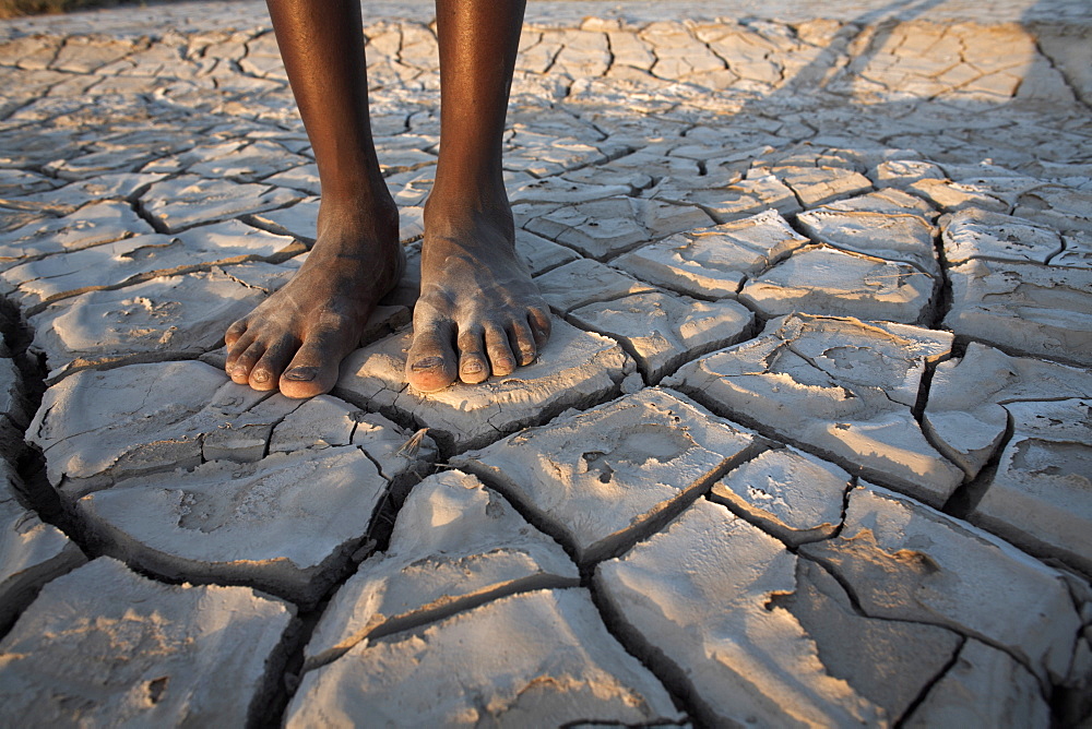 A boy stands in the desolate landscape of Lac Abbe, Djibouti, Africa