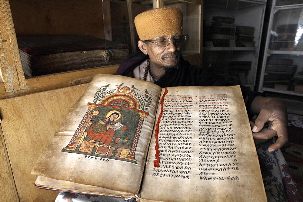 A priest goes through an ancient manuscript at the monastery of Kebran Gabriel, on an island on Lake Tana, Ethiopia, Africa