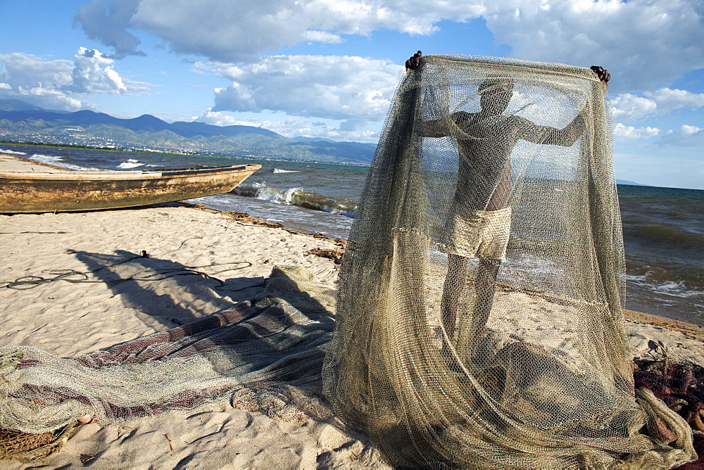 A fisherman tends his nets on Plage des Cocotiers (Coconut Beach) also known as Saga Beach, Lake Tanganyika, Bujumbura, Burundi, East Africa, Africa