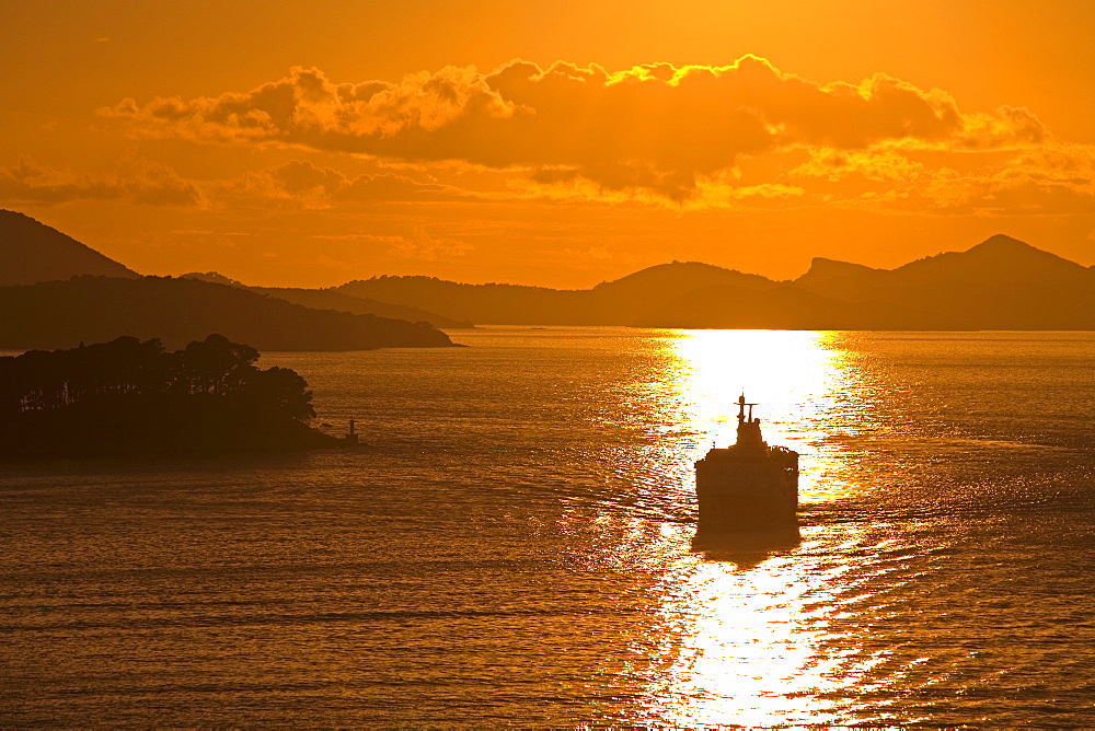 Cruise ship sails into sunset, Port of Dubrovnik, Dalmatia, Croatia, Europe