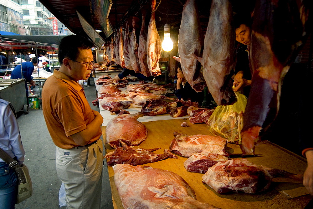 Man buying fresh meat at market, Xining, Qinghai, China, Asia