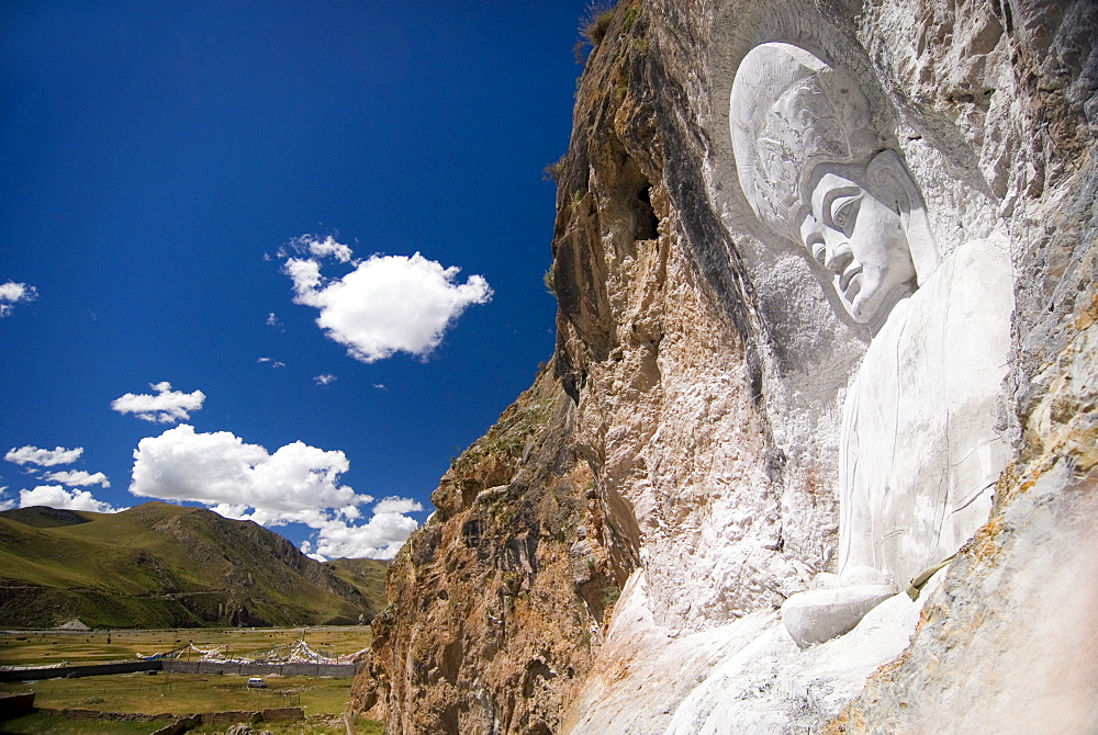 Buddha image carved into cliff side, Yushu, Qinghai, China, Asia