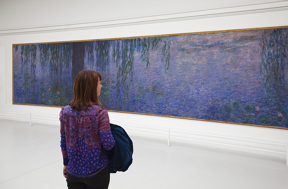 Lady looking at Monet's Water Lilies in the Orangerie Gallery, Paris, France, Europe